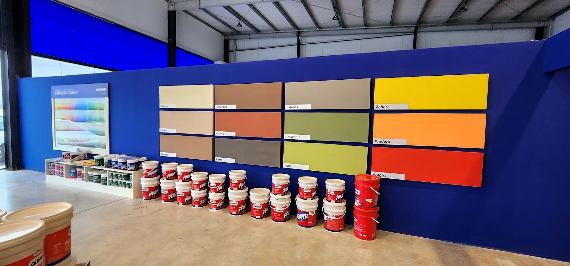 Espacio Color del local de pinturería, con muestras de colores y baldes Quimexur